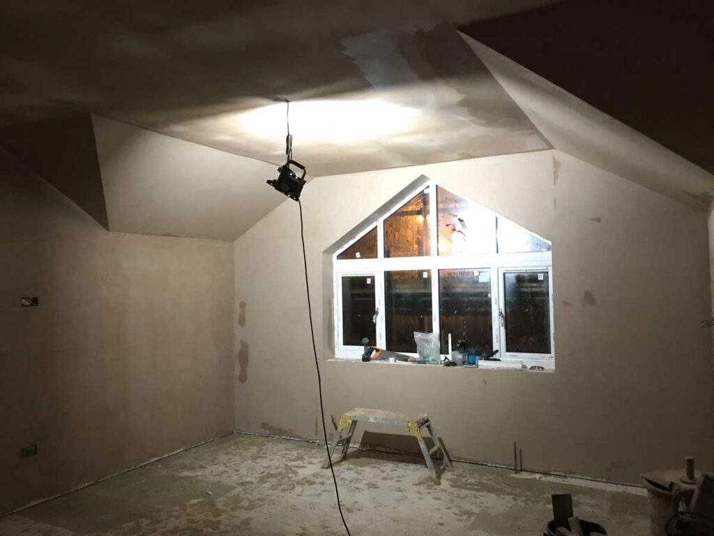 Interior plastering work in progress with freshly skimmed walls and ceiling